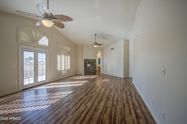 unfurnished living room with baseboards, high vaulted ceiling, ceiling fan, and wood finished floors