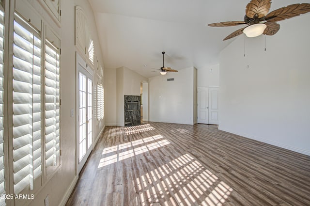 unfurnished living room with baseboards, high vaulted ceiling, ceiling fan, and wood finished floors