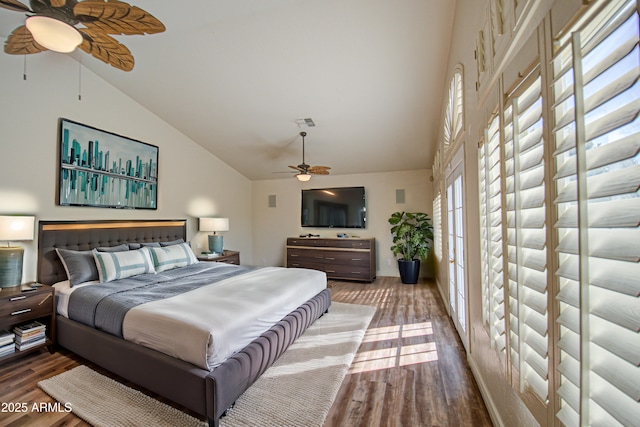 bedroom with ceiling fan, wood finished floors, and high vaulted ceiling