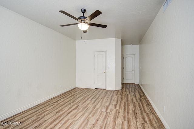 spare room with visible vents, wood finished floors, baseboards, and ceiling fan