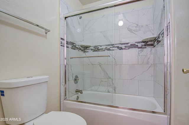 bathroom with toilet and combined bath / shower with glass door