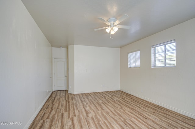 empty room featuring light wood-style flooring, a ceiling fan, and baseboards