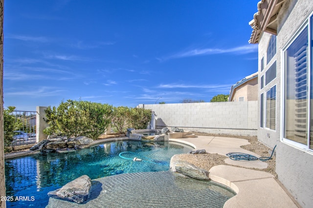 view of pool with a patio, a fenced backyard, and a pool with connected hot tub