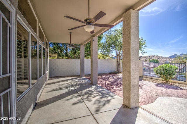 view of patio / terrace featuring a mountain view, a ceiling fan, and a fenced backyard