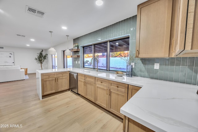 kitchen featuring visible vents, a peninsula, plenty of natural light, light wood-style flooring, and dishwasher