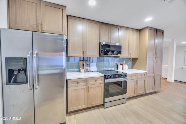 kitchen featuring decorative backsplash, light brown cabinets, recessed lighting, light wood-style flooring, and stainless steel appliances