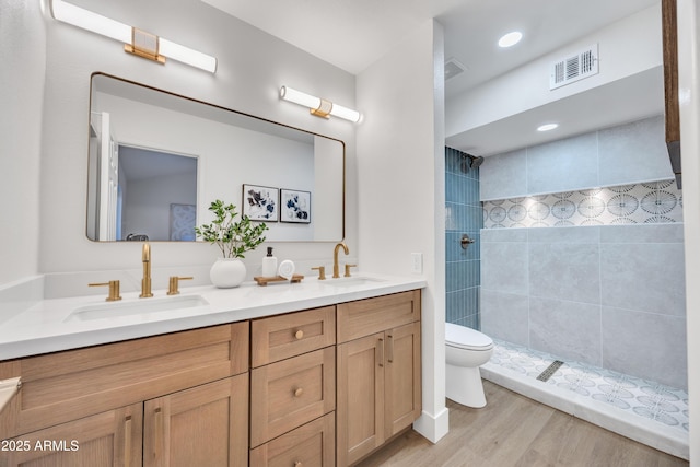 bathroom with a sink, toilet, double vanity, and visible vents