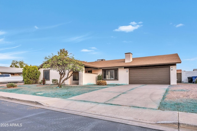 ranch-style home featuring an attached garage, concrete driveway, stucco siding, and a chimney