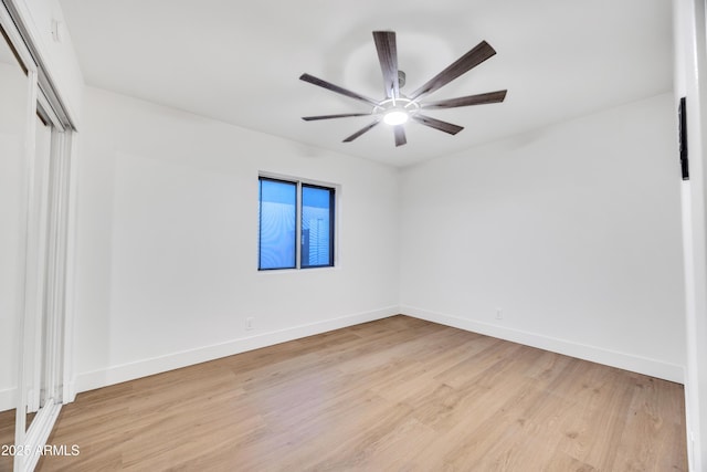 unfurnished bedroom featuring light wood-style floors, ceiling fan, baseboards, and a closet