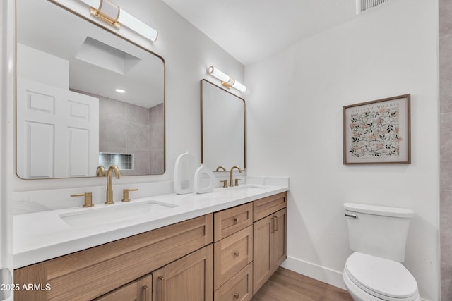 full bath featuring double vanity, toilet, visible vents, and a sink