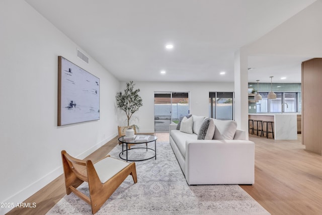 living area with visible vents, recessed lighting, baseboards, and wood finished floors