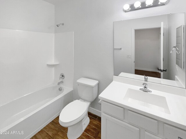 full bathroom with vanity, toilet, wood-type flooring, and bathing tub / shower combination