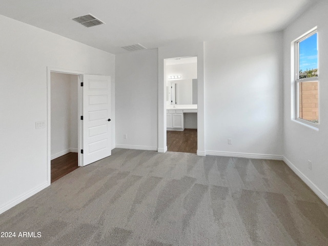 unfurnished bedroom with carpet and ensuite bathroom