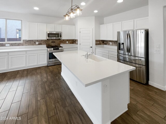 kitchen featuring stainless steel appliances, dark hardwood / wood-style flooring, an island with sink, sink, and decorative backsplash