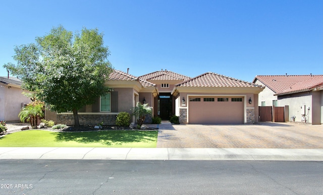 3529 E Desert Broom Dr, Chandler, AZ 85286 - mediterranean / spanish home with stone siding, a garage, a tile roof, stucco siding, and decorative driveway