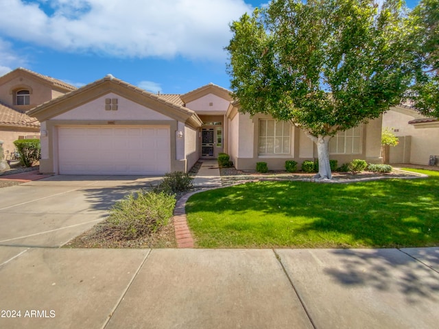 view of front of property with a garage and a front lawn