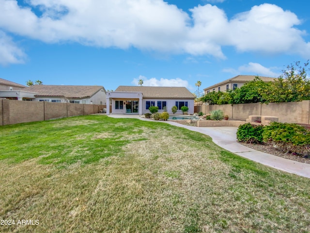 rear view of house featuring a patio and a lawn