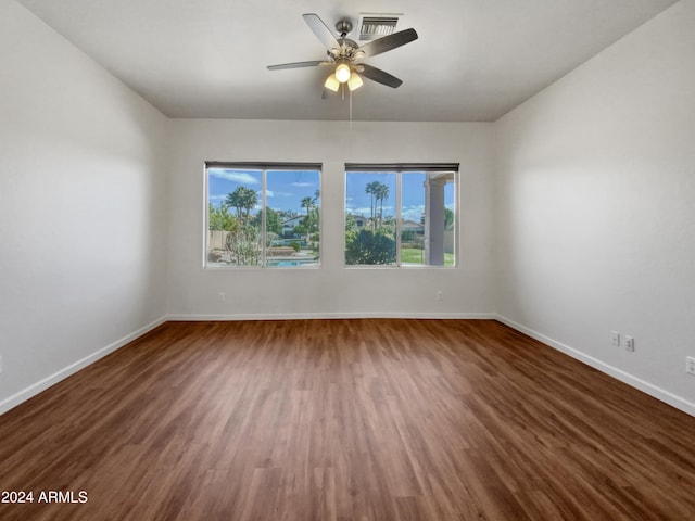 unfurnished room with ceiling fan and dark wood-type flooring