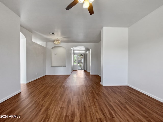 unfurnished living room with ceiling fan and dark wood-type flooring