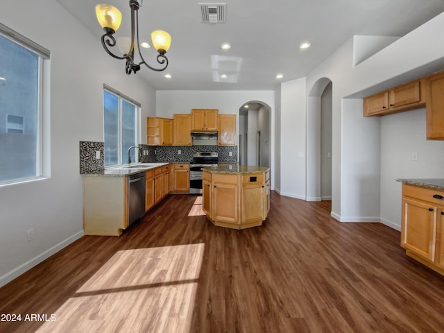 kitchen featuring light stone countertops, dark hardwood / wood-style floors, decorative light fixtures, and appliances with stainless steel finishes