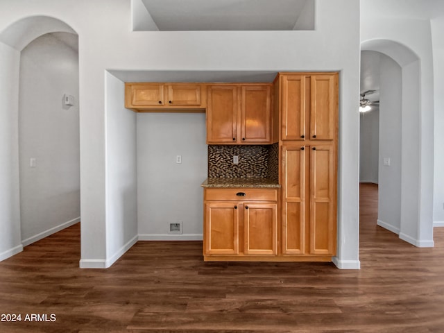 kitchen with ceiling fan, dark hardwood / wood-style floors, and backsplash