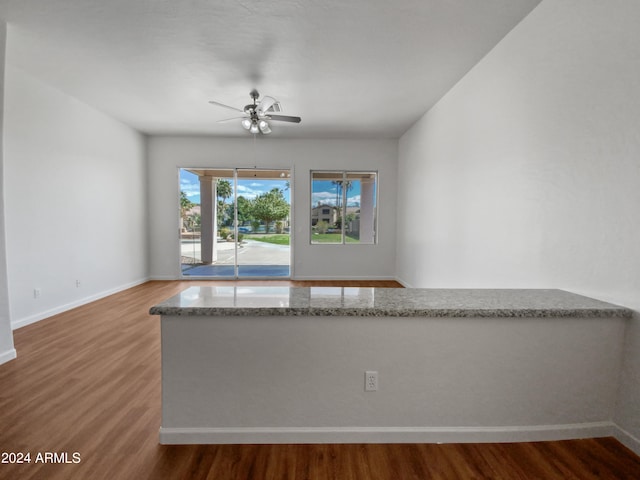 empty room with hardwood / wood-style floors and ceiling fan