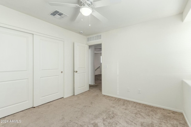 unfurnished bedroom with light carpet, a closet, and ceiling fan