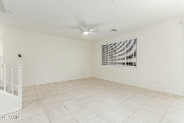 tiled spare room featuring ceiling fan