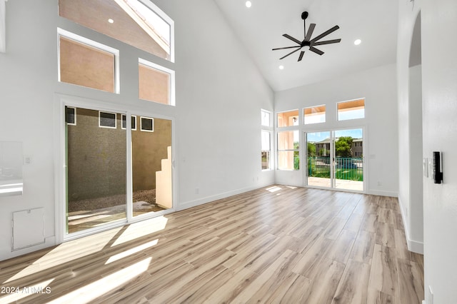 unfurnished living room with ceiling fan, high vaulted ceiling, and light wood-type flooring