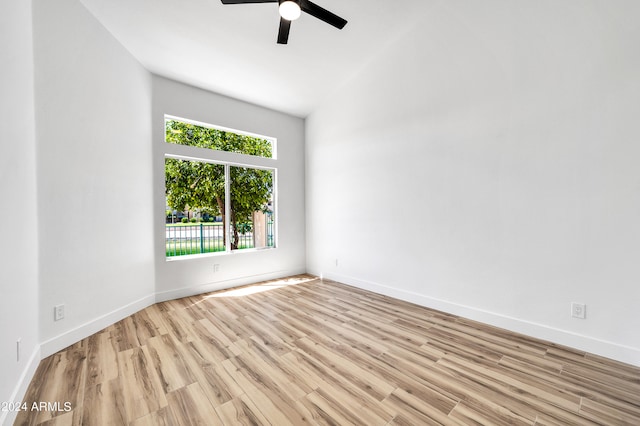 empty room with light hardwood / wood-style flooring, lofted ceiling, and ceiling fan