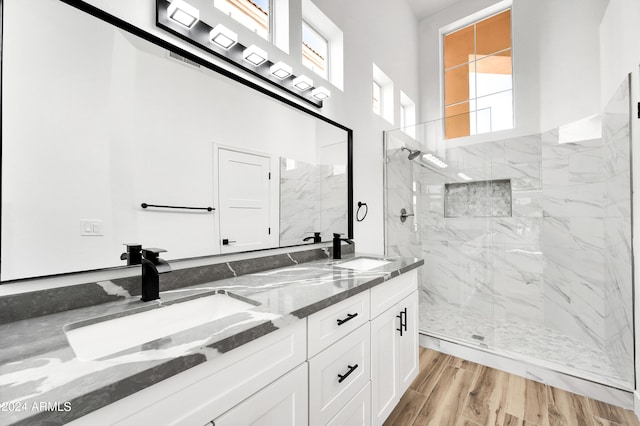 bathroom with vanity, wood-type flooring, and tiled shower