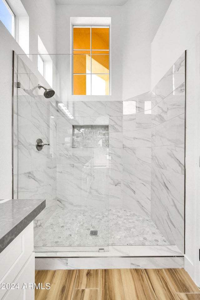 bathroom with vanity, tiled shower, and hardwood / wood-style floors