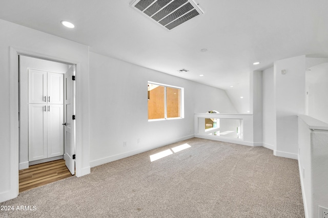 unfurnished living room featuring lofted ceiling and light colored carpet