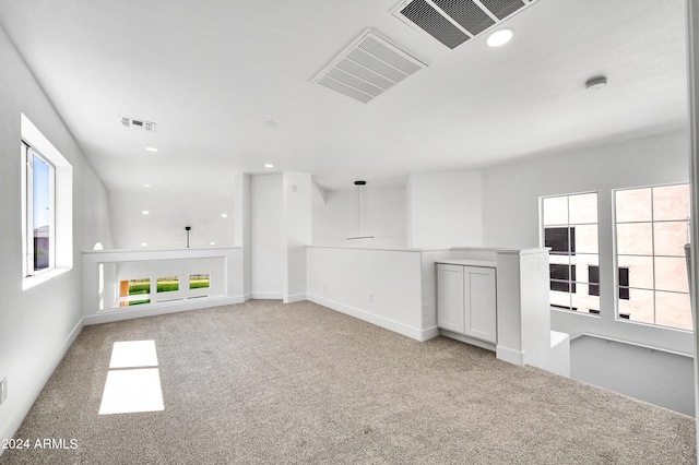 unfurnished living room with light colored carpet