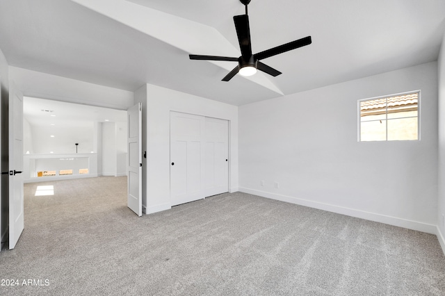 unfurnished bedroom featuring a closet, ceiling fan, and light carpet