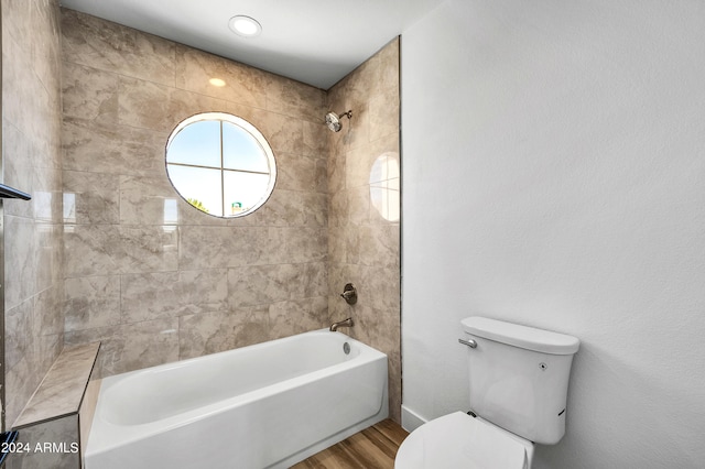 bathroom featuring toilet, tiled shower / bath combo, and wood-type flooring