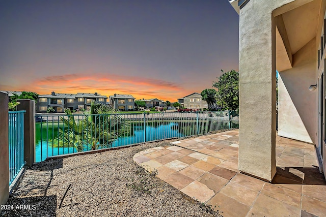 pool at dusk featuring a patio