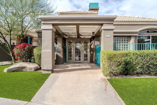 entrance to property featuring french doors and a yard