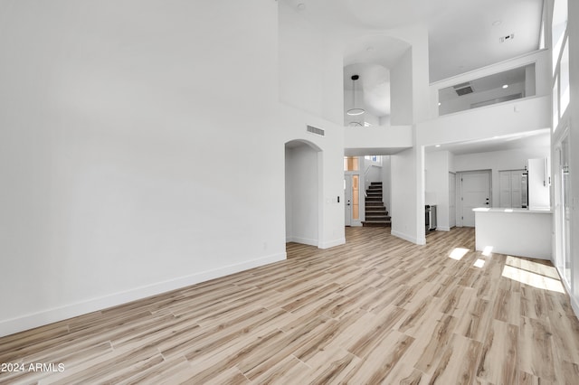 unfurnished living room featuring light hardwood / wood-style floors and high vaulted ceiling