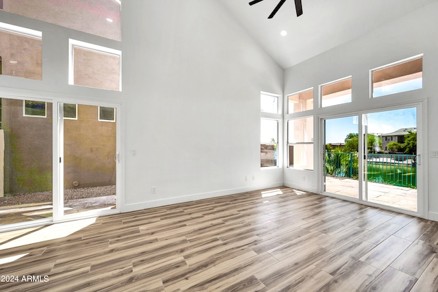 spare room featuring ceiling fan, high vaulted ceiling, and light wood-type flooring