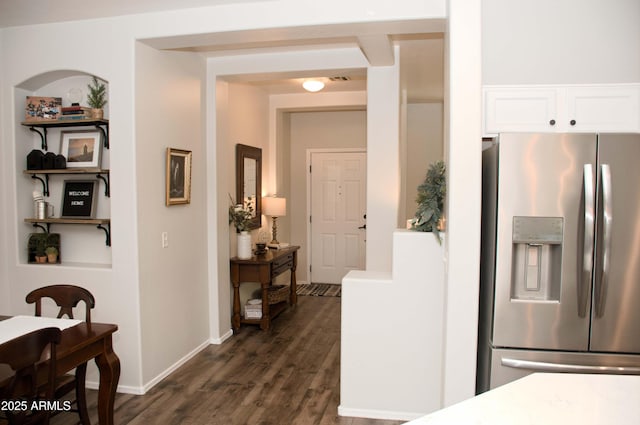 kitchen with white cabinetry, dark hardwood / wood-style floors, and stainless steel fridge