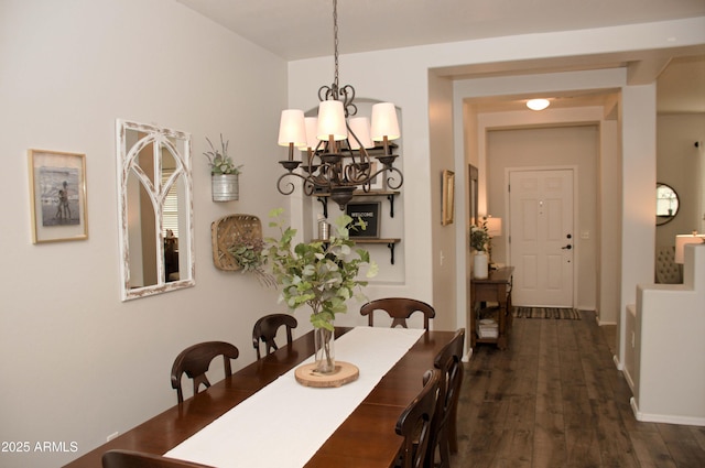 dining space featuring an inviting chandelier and dark wood-type flooring