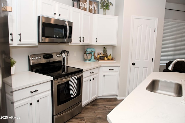 kitchen featuring stainless steel appliances, white cabinetry, and sink