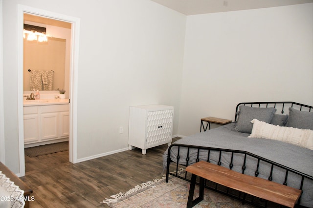 bedroom featuring ensuite bathroom, dark hardwood / wood-style floors, and sink