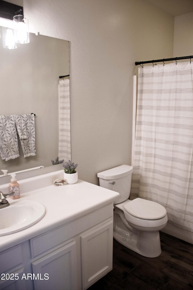 bathroom featuring vanity, curtained shower, wood-type flooring, and toilet