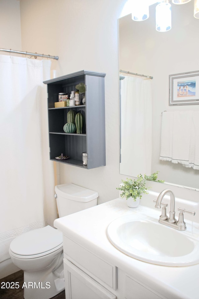 bathroom featuring vanity, walk in shower, and toilet