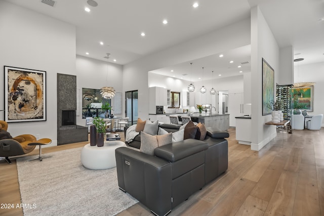 living room with a towering ceiling and light hardwood / wood-style flooring