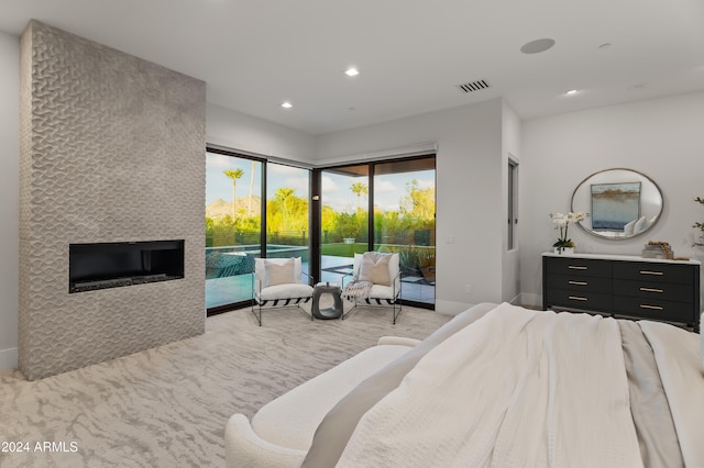 bedroom with access to outside, light colored carpet, and a fireplace