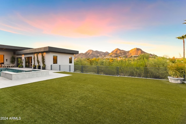 yard at dusk featuring a patio and a mountain view