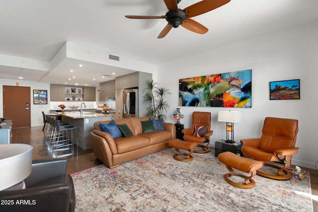 living area featuring a ceiling fan, dark wood-style flooring, visible vents, baseboards, and recessed lighting
